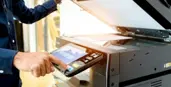 "A man typing on a professional copier"