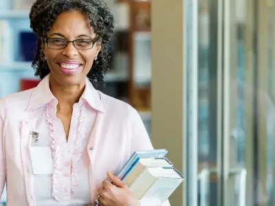 A smiling librarian faces the camera